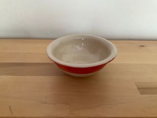 A little curvy bowl, clear glazed with the top half of its outside painted red.