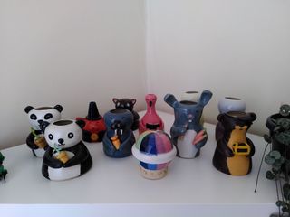 Various vases shaped as little animal characters on a shelf.
