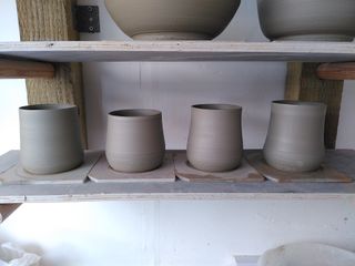 4 clay mug bodies on their bats after throwing