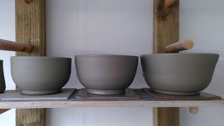 Three bowls of increasing size on their bats, waiting to dry