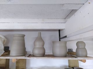 An angular vase, a double gourd vase, bulbous planter and 'head and body' vase, on their bats after throwing.
