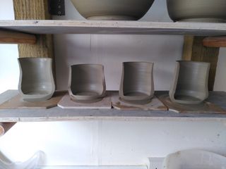 4 thrown mug bodies cut in half exposing their regular rim 