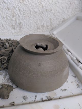 Upside down trimmed pot with torn hole in its bottom.
