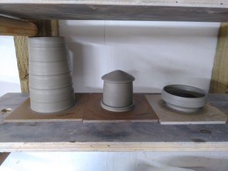 Tower, top and balcony of a lighthouse, in wet clay, on their bats on a shelf. 
