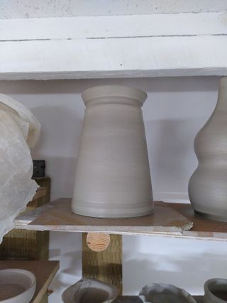 Close up of an angular vase with an indented stripe on its bats after throwing.
