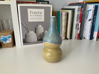 A double gourd vase glazed in two colour blocks separated by a wavy stripe of raw clay, top light blue and bottom light yellow-green.