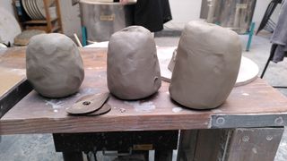 Three balls of clay of increasing size on a table, next to throwing ribs.