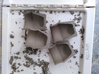 Halves of two cups drying on the reclaim box