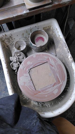 Pottery wheel super dirty with wet clay after throwing.
