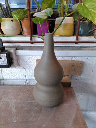 A double gourd vase waiting to dry on a shelf