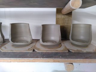 Half cuts of 3 thrown mug bodies, showing their regular rims