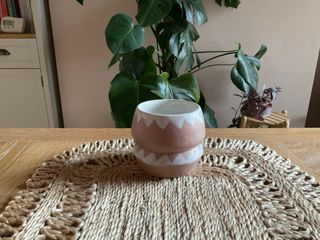 An angular matt peach planter with white triangles motif at its rim and middle and a matt white inside.