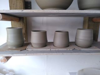 4 clay mug bodies on their bats after throwing