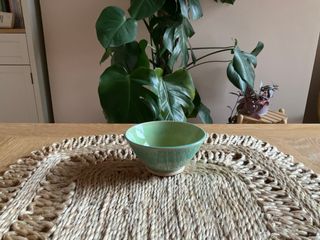 
A light and tiny bowl, with a light green glaze inside and a light blue green glaze outside, at time transparent-ish.