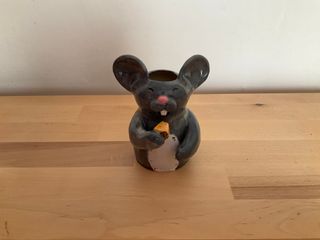 A little vase in the shape of a mouse, its mouth wide open ready to bite again into a piece of cheese.

**Note**: Outside glaze is irregular and a little patchy/thin in places. Inside is good, though and the vase is watertight.