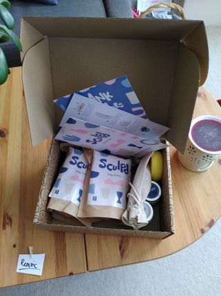 A parcel open on a table containing bags of Sculpd air dry clay