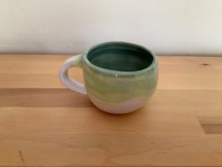 Chunky mug with waves of green overlaid on top of each other.