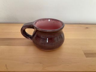 A chunky dark purple mug with a pink inside. 