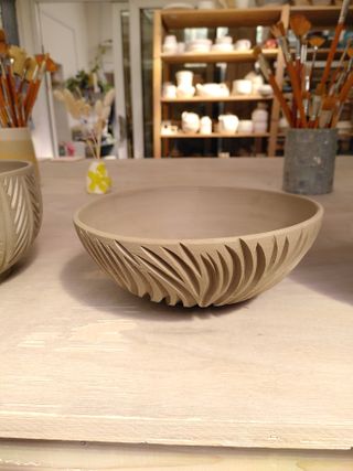 A bowl with carved marks flowing from its bottom organically