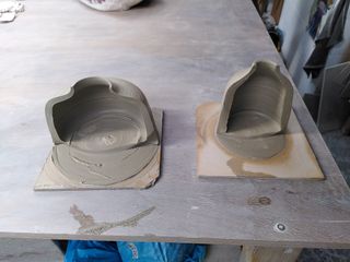 Two clay forms on bats cut in half, showing pretty thick walls.