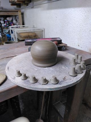 Trimmed upside down clay cauldron and a selection of thrown feet. 