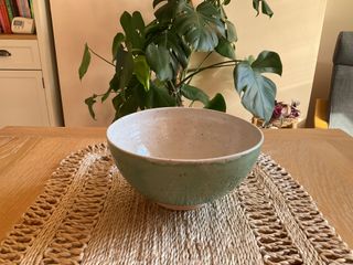 
A slightly oval bowl with a glossy, speckled, green blue glaze outside and a glossy speckled white inside overflowing at the rim.

**Note**: The foot is not super flat and the bowl wobbles a bit 😅
