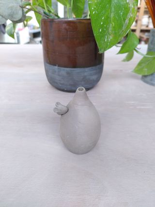 Front picture of a leather dry tiny bulbous vase with a little mouse climbing its collar