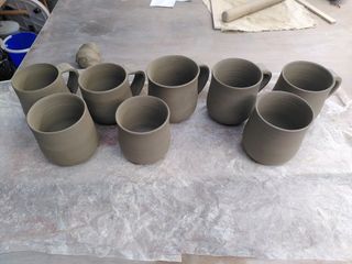 Set of 8 mugs bodies of slightly varying size but all lightly bulbous, 5 of them with their handles attached