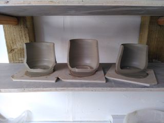 3 thrown mug bodies cut in half exposing their regular rims