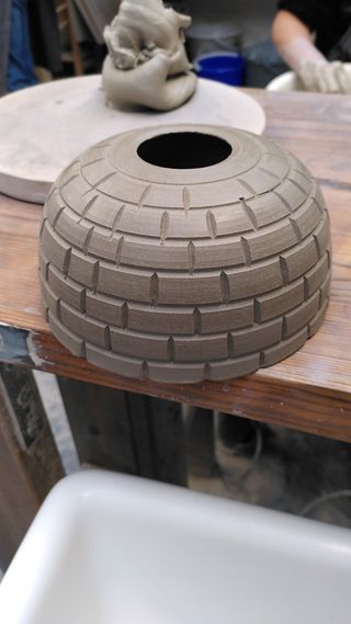 Clay form shaped and carved like an igloo.