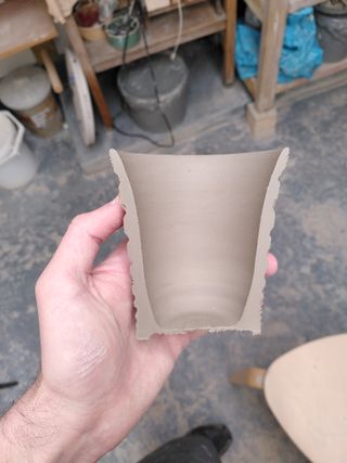 A half-cut of a flared tumbler with carved stripes