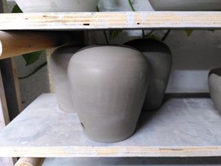 Three trimmed table lamp bases, tapering at the bottom before curving at the top.