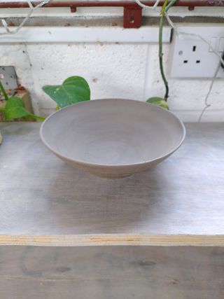 A leather dry clay wide bowl drying on a shelf