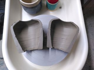 Clay form cut in half showing a very thick wall at the bottom.