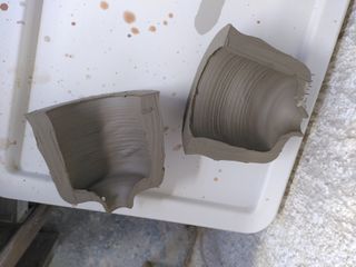 A thick walled clay form cut in half