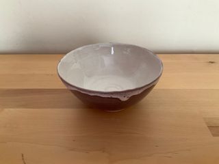 Bowl glazed purple outside and a white inside glaze generously overflowing outside at its top