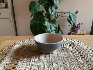 A bowl in matt glazes, cream inside and dark blue outside.