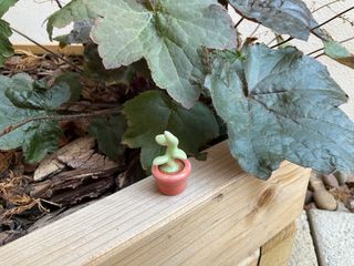 A super tiny planter with a sprouting ceramic plant