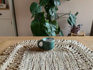 A dark green espresso cup with a speckled white inside.