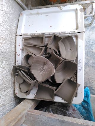 Reclaim clay box packed with leather hard halves of ceramic pieces