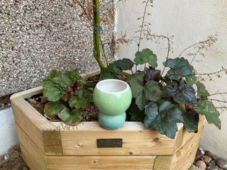 A vase shaped as a green ball atop a smaller green-blue one