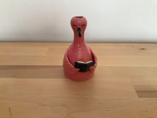 Bud vase in the shape of a flamingo happily reading a blue book.

**Note**: For dry flowers only, bottom has a hole and the pot is **not watertight**.