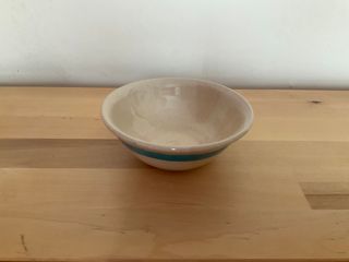 A little curvy bowl, clear glazed with a blue stripe outside near its rim.