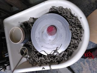 A pottery wheel filled with clay trimmings