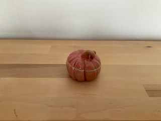 A tiny muted orange pumpkin with a lid.