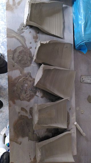 Half cut clay cylinders, with a fairly thick rim at the bottom and a thinner rim at the top